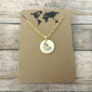 Small circular crescent moon charm necklace in gold tone